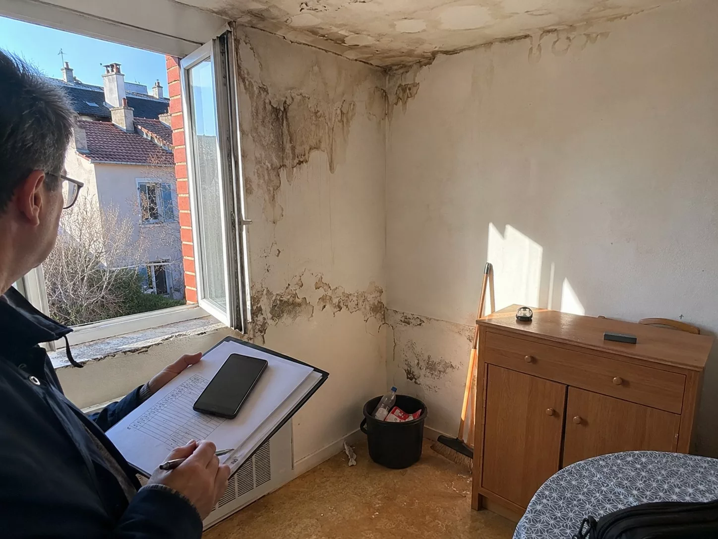 Inspection de dégâts des eaux dans un appartement avec rapport d’expert assurance contesté, moisissures visibles sur mur et plafond, 2026-07-08, format 4/3.