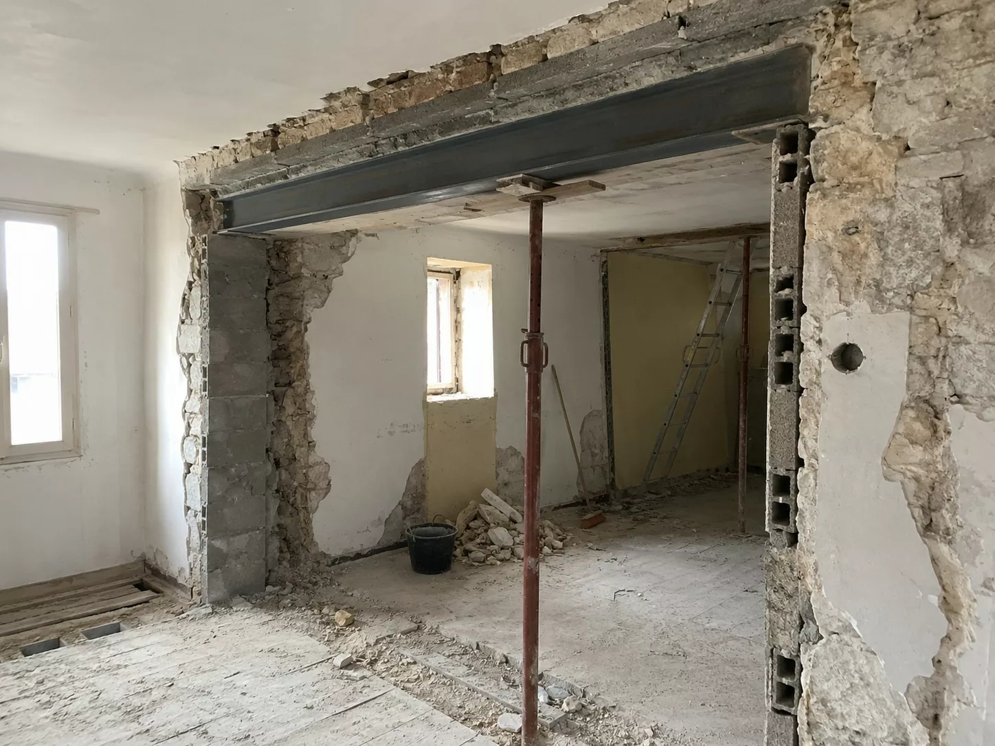 Ouverture d'un mur porteur avec poutre métallique IPN installée pendant la rénovation d'une maison